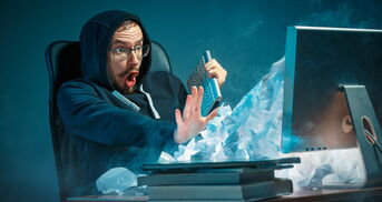 Mann wird vor dem PC von E-Mails überflutet