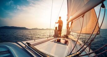 Boot segelt mit Paar in den Sonnenuntergang