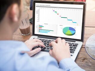 Mann am Laptop mit Statistik