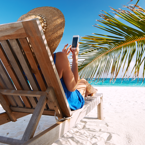 Frau mit Handy am Strand in Liege