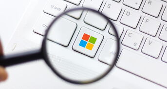 Eine Lupe vergrößert die Windowstaste auf einer Tastatur