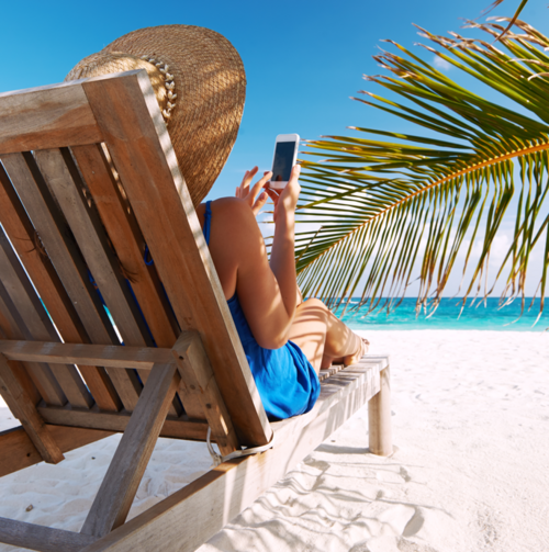 Frau mit Handy am Strand in Liege
