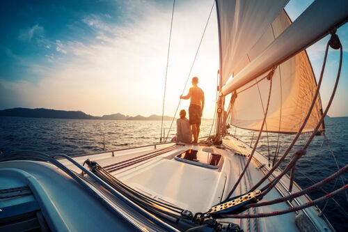 Boot segelt mit Paar in den Sonnenuntergang