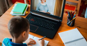 Junge sitzt vor Videokonferenz Unterricht
