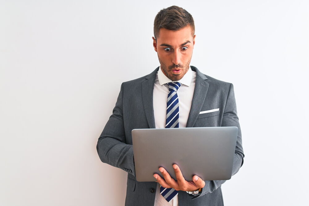 Mann erschrickt vor Laptop