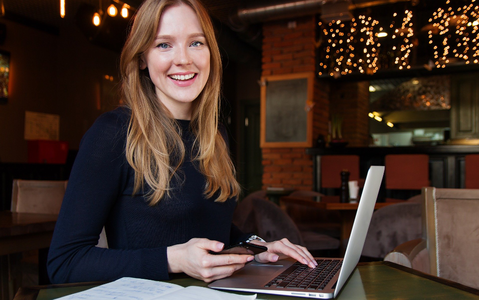 frau gluecklich am laptop und handy