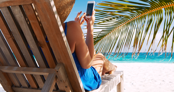 Frau mit Handy am Strand in Liege